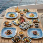 Ahşap tekne masasında istiridye, deniz ürünleri, tartar, şarküteri ve gurme mezelerle sunulan açık mavi iris reaktif sir efektli kırılmaz melamin 16 parça Blue Iris (504316) kare ve kayık sunum seti.