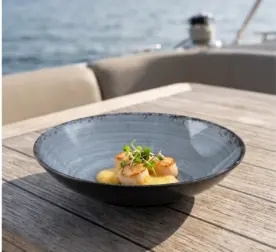 Ahşap tekne masasında köpüksü sarı gurme sos ve taze mikro filizler eşliğinde tavada mühürlenmiş deniz tarağı (scallop) ikramıyla gösterilen dairesel spral ve çatlatmalı sır efektli lacivert-mavi mermer dokulu kırılmaz melamin 3'lü yuvarlak geniş çukur yemek, makarna ve çorba tabağı seti (Ø 23 cm, 540 ml).