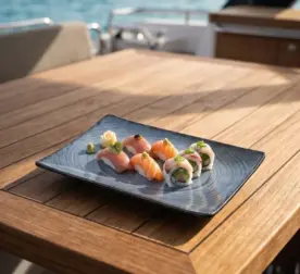 Ahşap tekne masasında somon ve ton balıklı nigiri ile sushi roll çeşitleri, vasabi ve zencefil turşusu sunumuyla gösterilen dairesel halka efektli lacivert-mavi mermer dokulu kırılmaz melamin 6'lı dikdörtgen servis ve sunum tabağı seti (20 x 13,7 cm).